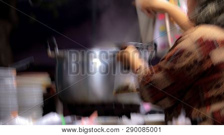 Blur Scooping Food From The Boiler To Put Bags For Customers