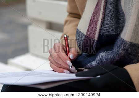 Woman Hand With Red Pen Completing A Form.