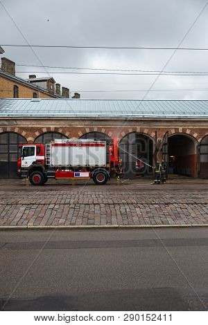 Riga, Latvia - March 16, 2019: Driver Washes Firefighter Truck At A Depo From Behind - Fire Truck Is