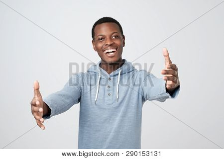 Cheerfull African Man, Pulling Hands Towards Camera, Wanting To Cuddle
