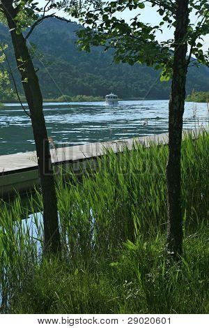 Reed, river and approaching boat in the distance