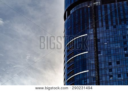 Closeup High-rise Glass Building With Overcast Sky In Half Of The Frame