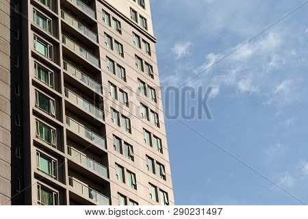 Partial View Of High-rise Building With Balconies And Windows On Clear Sky Background