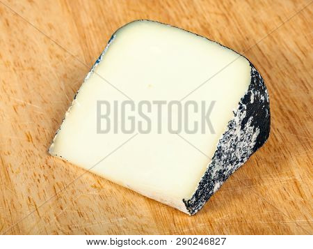 Italian Perla Nera Sheep Cheese On Cutting Board