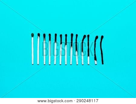 Burned Matches In A Row On A Blue Background. The Concept Of Depression, Extinction, Illness, Burnou