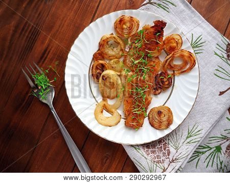 Grilled Fish On White Plate With Onions And Micro Greens