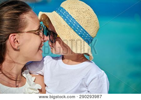Three year old toddler boy on beach eskimo kissing his mother. Summer family vacation at Maldives.