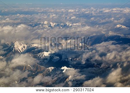 Flying near high mountain ranges of the Himalayas, view through airplane window