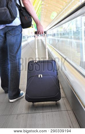 Traveler with a suitcase on the speedwalk