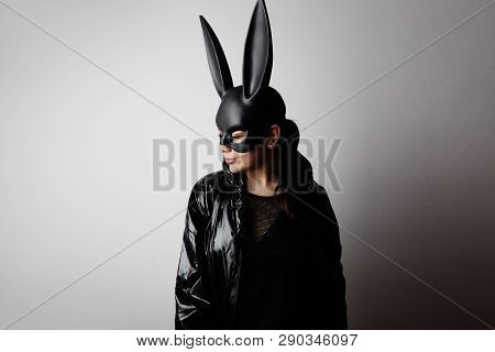 Sexy Young Woman With Red Lipstick And Large Breasts Wearing A Black Mask And Leather Jacket. Easter