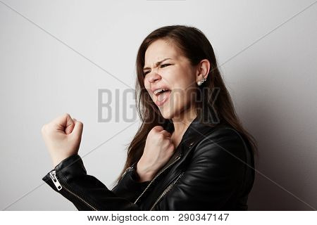 Fashion Photo Of A Beautiful Brunette Woman Wearing Leather Jacket With Dark Long Hair Posing Over W