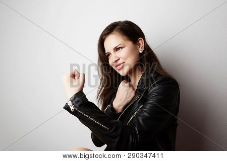 Fashion Photo Of A Beautiful Brunette Woman Wearing Leather Jacket With Dark Long Hair Posing Over W