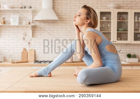 Languid Blonde Young Woman Resting On Kitchen Table