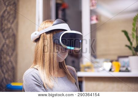 A Young Blond Caucasian Sick Girl Covers Her Face And Wears A Virtual Reality Headset Enjoys Virtual