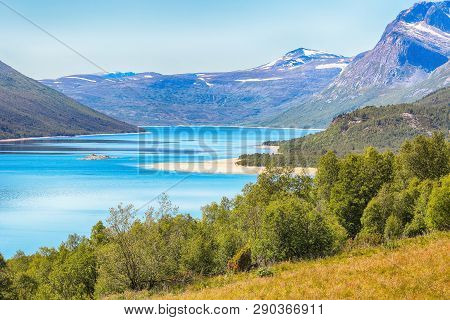 Lake Gjevillvatnet Located Near The Norwegian Town Oppdal With Sandy Beach And Mountains, The Popula