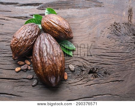 Cocoa pod and cocoa beans on the wooden table. Top view.
