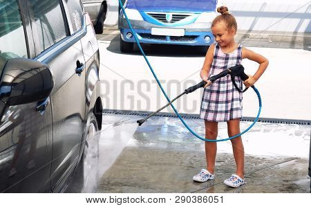 Little Girl Washing Auto In Self-serve Car Wash