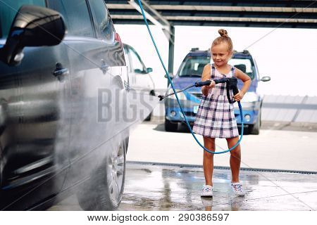 Little Girl Washing Auto In Self-serve Car Wash