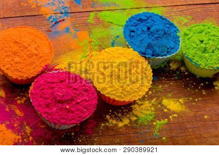 Colorful Holi powder in cups closeup. Bright colours for Indian holi festival in circle of clay pots. Selective focus