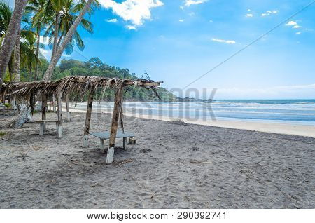 Itacarezinho Beach, Wooden Bench With Dry Straw Cover In The Sand Of The Beach.