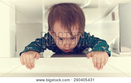 Cute Caucasian Baby Girl Crawl Through Tight Space Under Coffee Table Towards Camera.garbing Edge Of