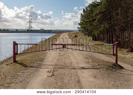Closed Forest Path By The Water Channel. A Barrier On A Forest Duke By The River. Season Of The Spri