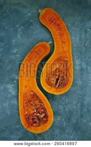 Two Halves Of A Pear-shaped Pumpkin Of Orange Color Are Located Vertically Close To Each Other Again