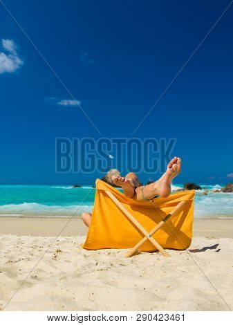 Woman enjoying her holidays on a transat at the tropical beach in Thailand