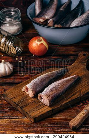 Hake Carcasses On Cutting Board With Pepercorn, Garlic And Salt