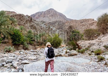Muscat, Oman - December 16, 2018: Female Tourist Is Walking Along The Wadi - A Dried Up Riverbed - I