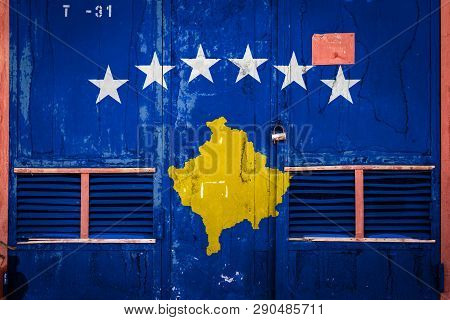 Close-up Of Old Warehouse Gate With National Flag Of Kosovo. Concept Of Kosovo Export-import, Storag