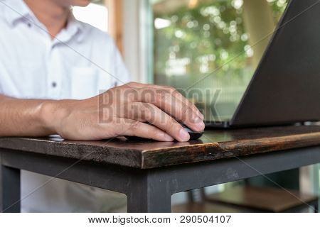 Asian Tan Skin Holding Wireless Mouse On The Vintage Wood Table