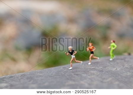 Miniature People Running On The Rock , Health And Lifestyle Concepts.