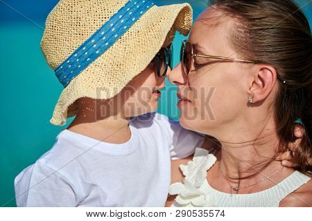 Three year old toddler boy on beach eskimo kissing his mother. Summer family vacation at Maldives.
