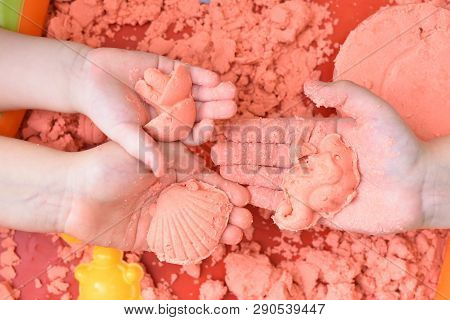Children Play With Pink Kinetic Sand For Sculpting Figures. Top View, Hands Close Up