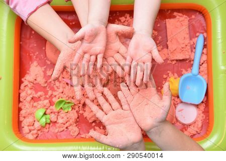 Children Play With Pink Kinetic Sand For Sculpting Figures And Show Their Hands. Top View, Hands Clo
