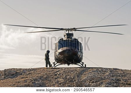 Pilot Checking Military Helicopter Before Taking Off From Helipad On Top Of Mountain. Military, Airf