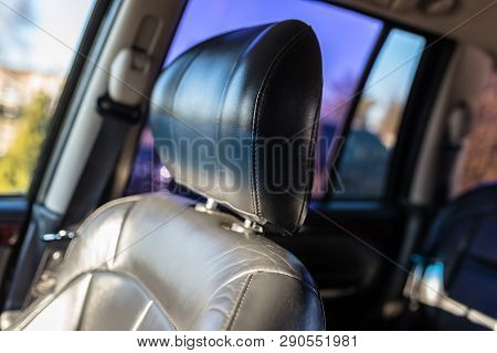 Leather Car Headrest Illuminated By The Sun, Inside The Used Car, Visible Signs Of Use.