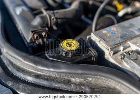 Steering Reservoir For Power Steering Fluid Inside The Engine Compartment, Visible Battery Clamp.