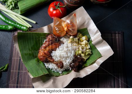 Nasi lemak kukus with chicken, popular traditional Malay local food. Flat lay top down overhead view.