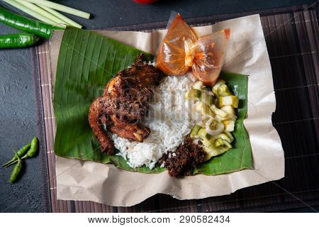 Nasi lemak kukus with quail, popular traditional Malay local food. Flat lay top down overhead view.