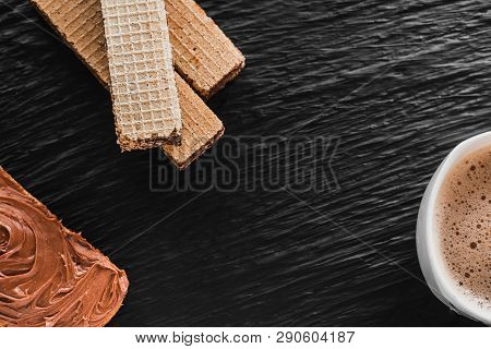 Close-up Of Coffee Cup With Roasted Coffee Beans On Wooden Background. View From Top