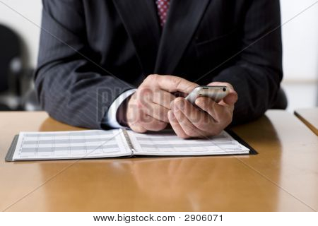 Homme d'affaires contrôle son emploi du temps sur téléphone portable.