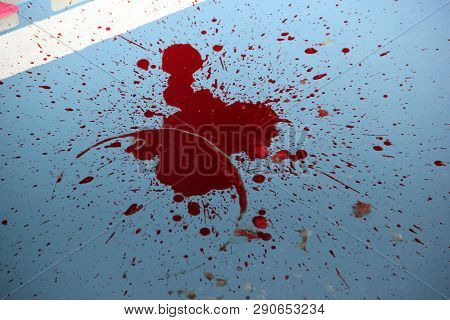 red blood on the floor from which the spray flew off
