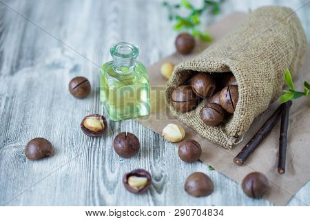 Macadam Nuts, Walnut Oil, On Wooden Background. Relax, Health Care, Body Care