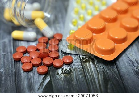Pills In Capsules And Blister Pack On Dark Wooden Table, Medication Close-up. Concept Of Pharmacy, F