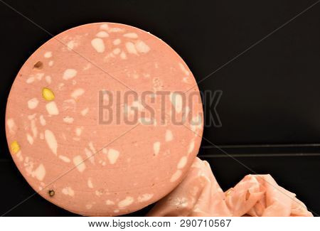 Meat Sausage With Fat, A Whole Round And Thin Cutting On A Black Background