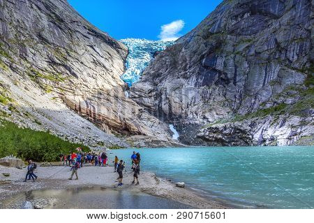Norway, Olden - August 1, 2018: People At Near Lake And Briksdal Or Briksdalsbreen Glacier With Melt