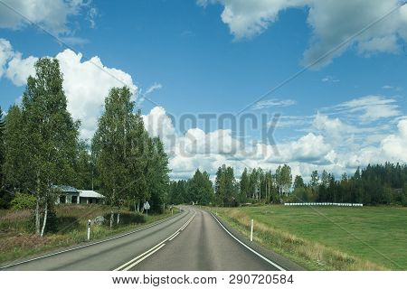 Fields, Trees And Road With Blue Sky And Clouds