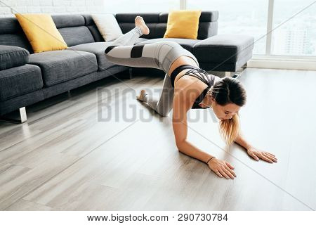 Adult Woman Training Legs And Back Doing Plank Donkey Kicks